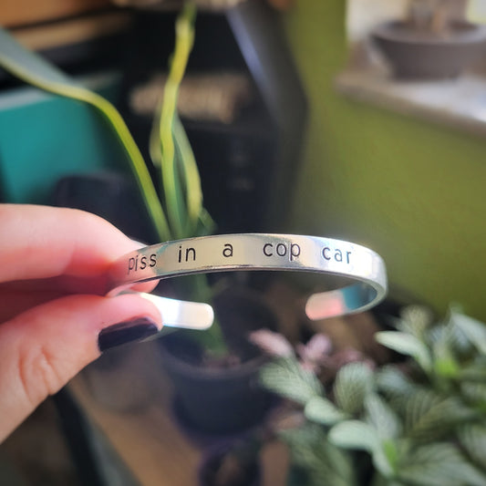 Piss in a Cop Car cuff bracelet